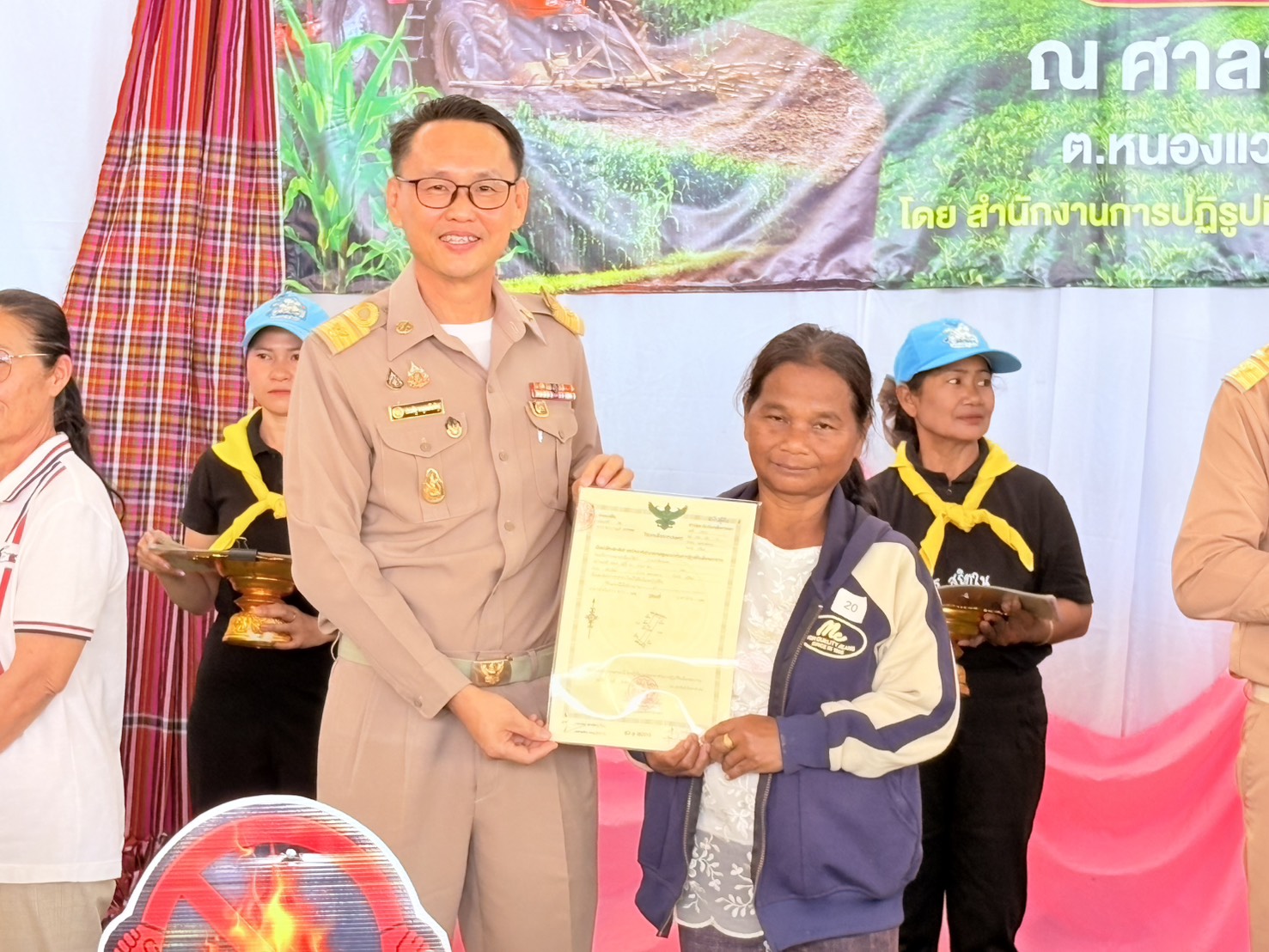 title - วันที่ 23 กุมภาพันธ์ 2569 นายประเสริฐ กาญจนเกียรติกุล ปฏิรูปที่ดินจังหวัดบุรีรัมย์ พร้อมเจ้าหน้าที่ ส.ป.ก.บุรีรัมย์ จัดโครงการอบรมก่อนมอบหนังสืออนุญาตให้เข้าทำประโยชน์ในเขตปฏิรูปที่ดิน (ส.ป.ก. 4-01) โดยมีนายคำเคลื่อน พณะชัย รองผู้ว่าราชการจังหวัดบุรีรัมย์ เป็นประธานในการมอบ ส.ป.ก. 4-01, โฉนดเพื่อการเกษตร แก่เกษตรกรที่เข้าร่วมโครงการ และร่วมรณรงค์ลดการเผาในเขตปฏิรูปที่ดิน